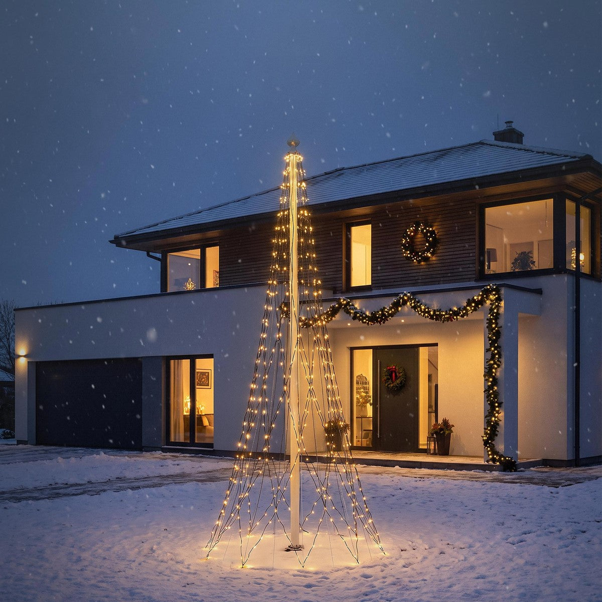 Leuchtendes kegelförmiges Lichternetz im verschneiten Vorgarten vor einem modernen Haus bei Nacht.