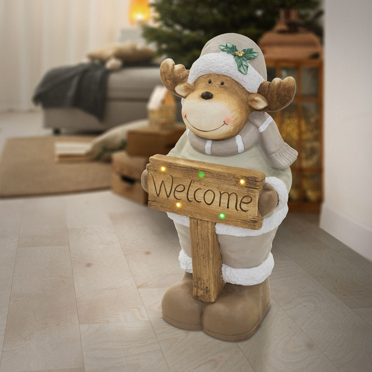 Ein brauner Bär in Winterkleidung mit einem 'Welcome'-Schild, im Raum stehend.