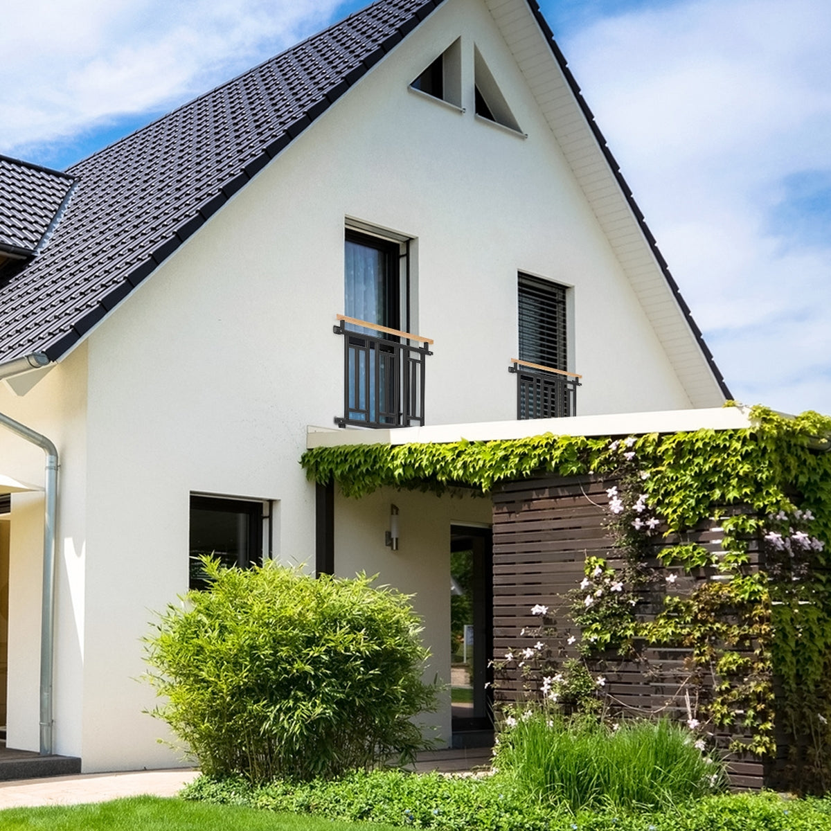 Ein modernes, zweigeschossiges Haus mit einem begrünten Eingangsbereich.
