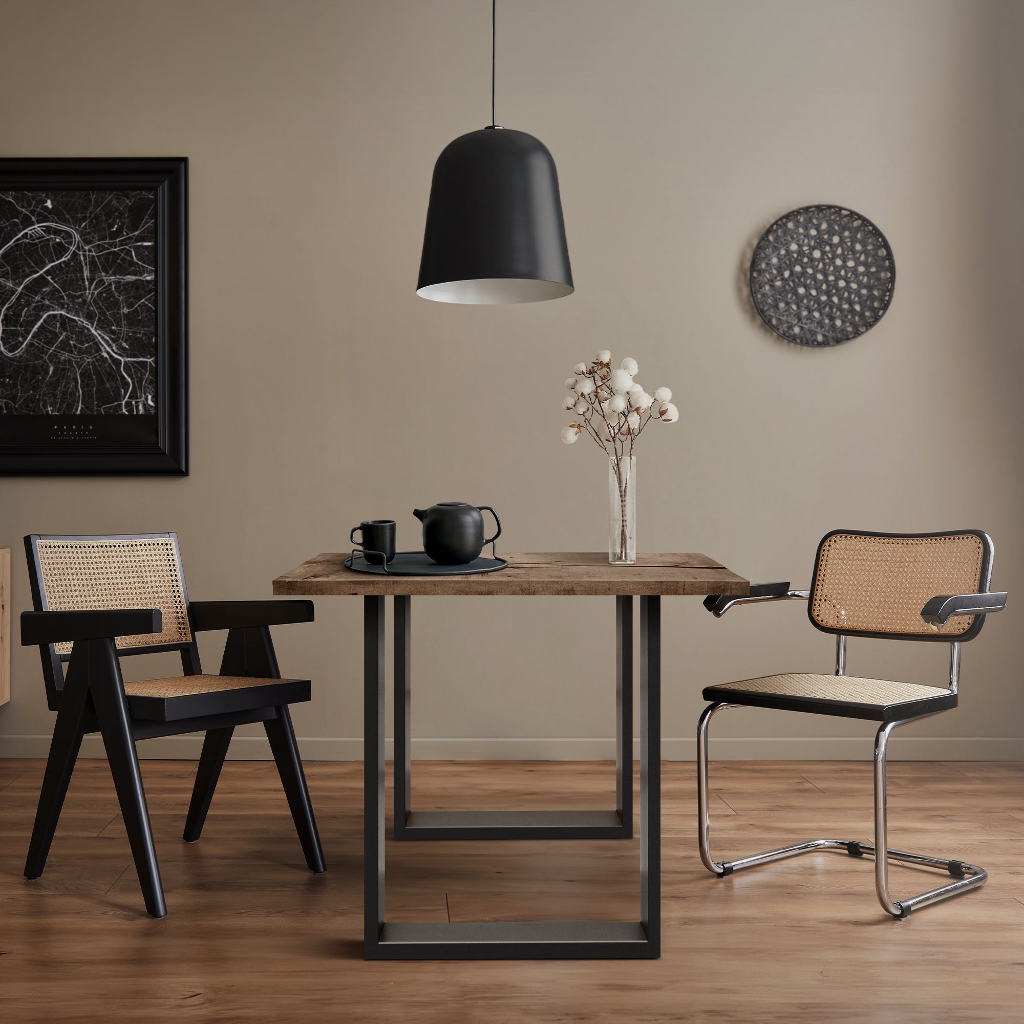 Tisch mit Geschirr und einer Vase in einem stilvollen Raum mit Holzfußboden.
