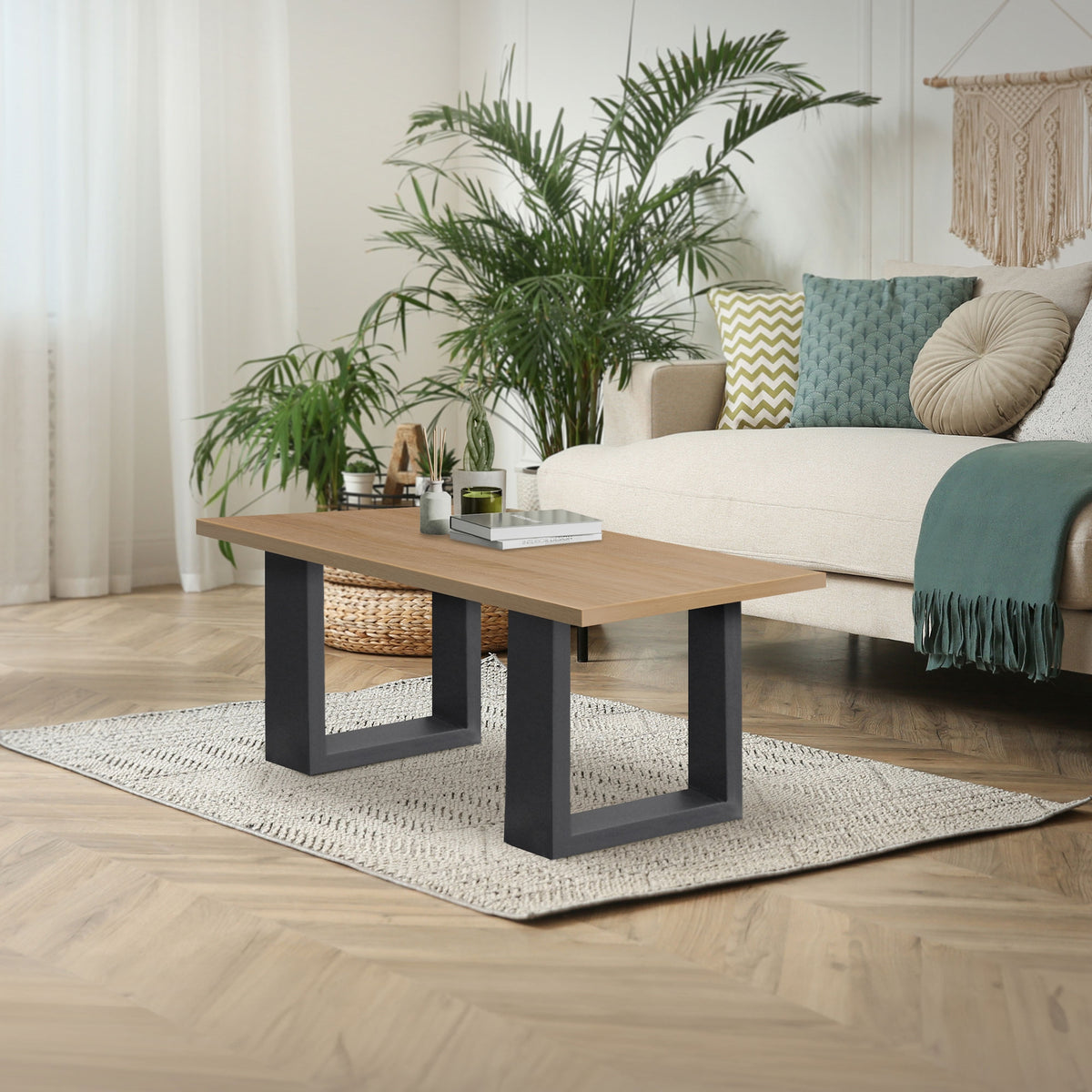 Stue med et bord, en sofa og planter i baggrunden.