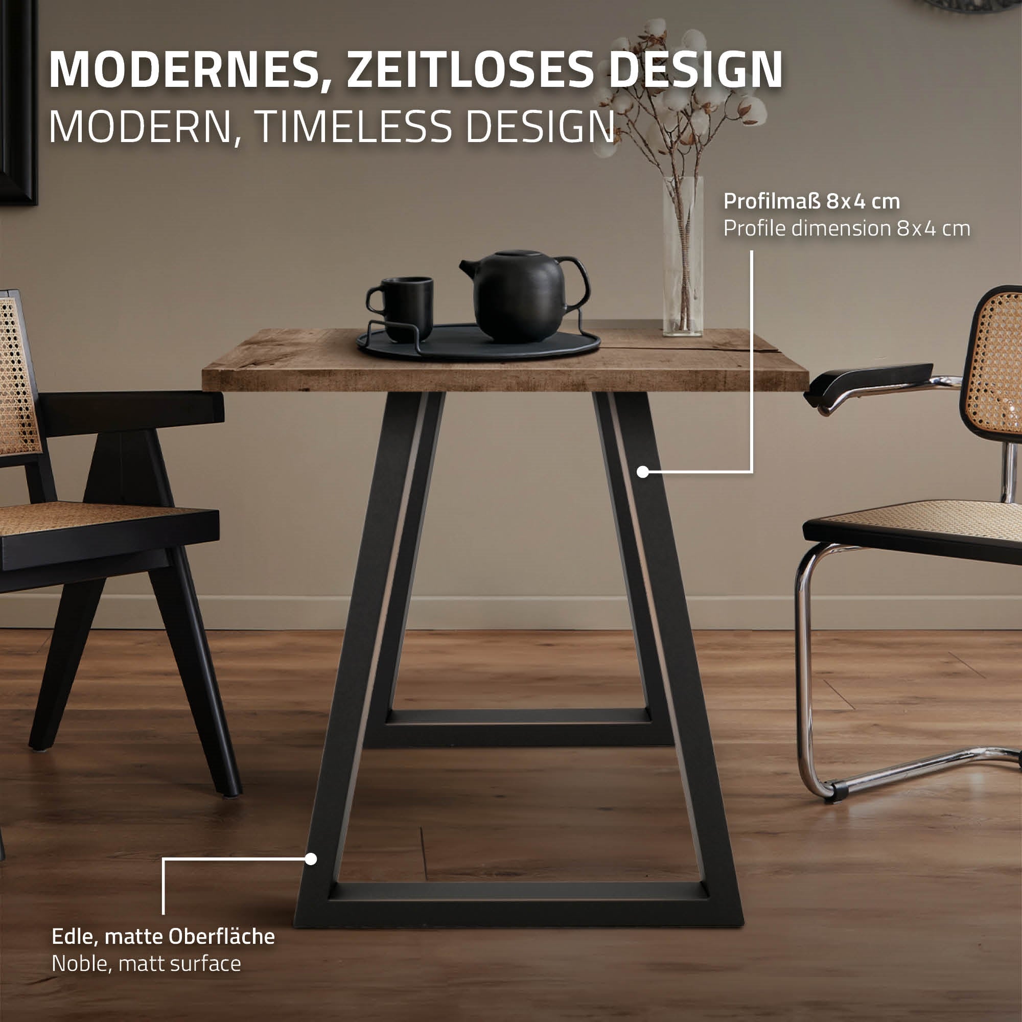 Tisch mit Holzplatte und schwarzen Beinen, Stühle mit geflochtenen Sitzen.