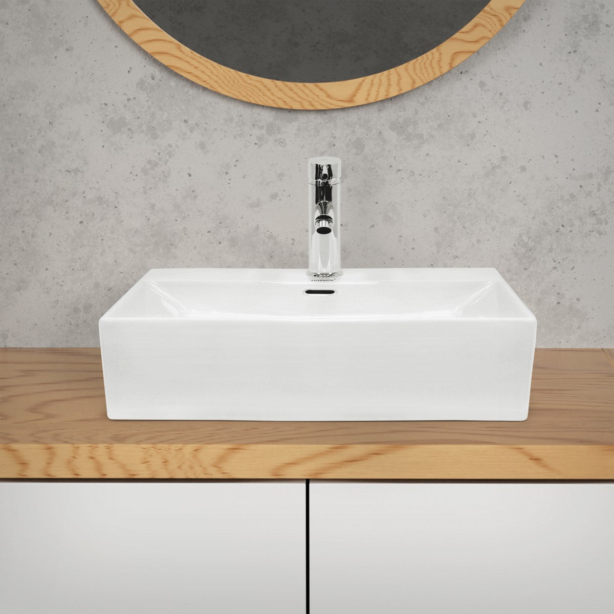Rechteckiges, weißes Waschbecken auf einem Holzschrank.