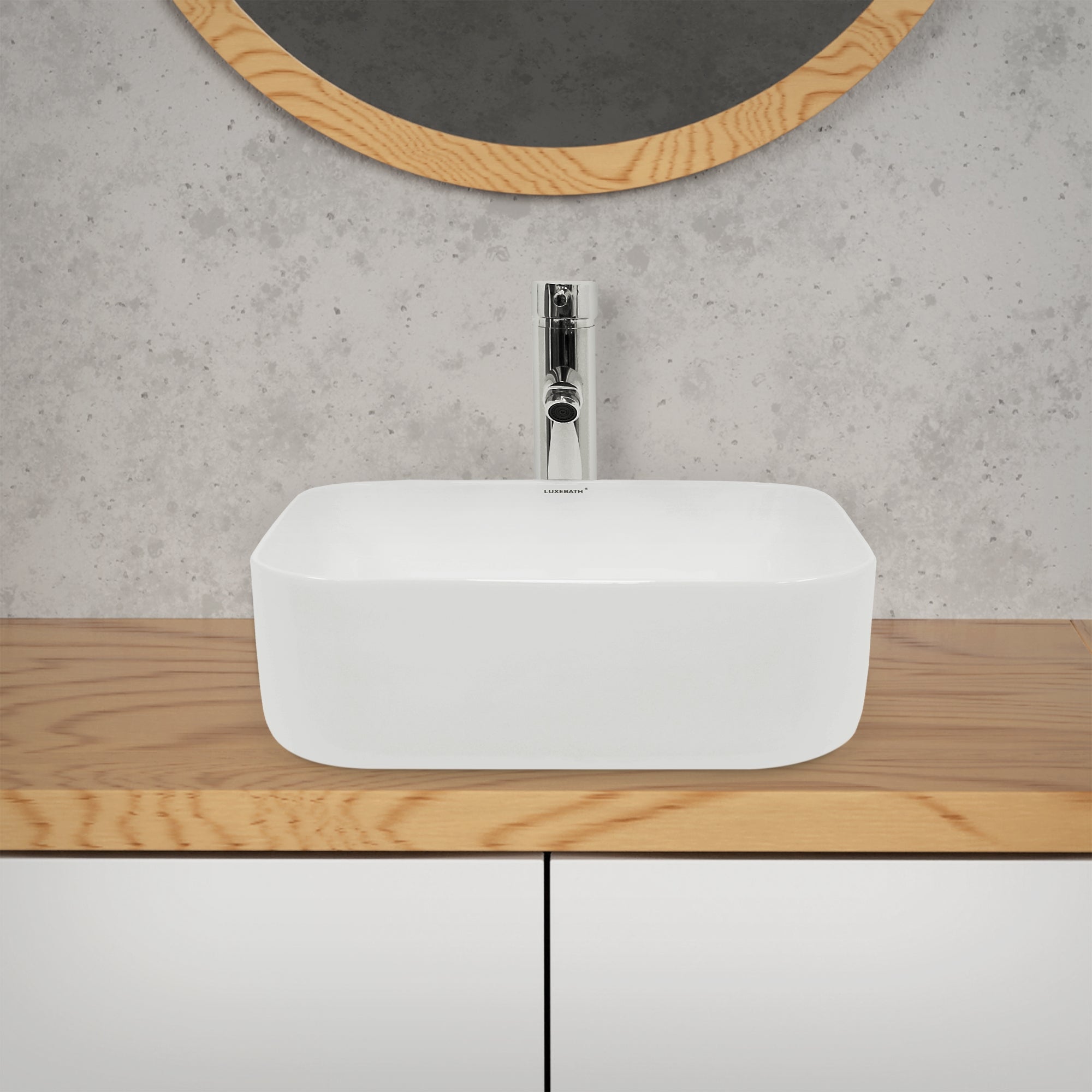 Lavabo blanc sur une surface en bois, avec un miroir en arrière-plan.