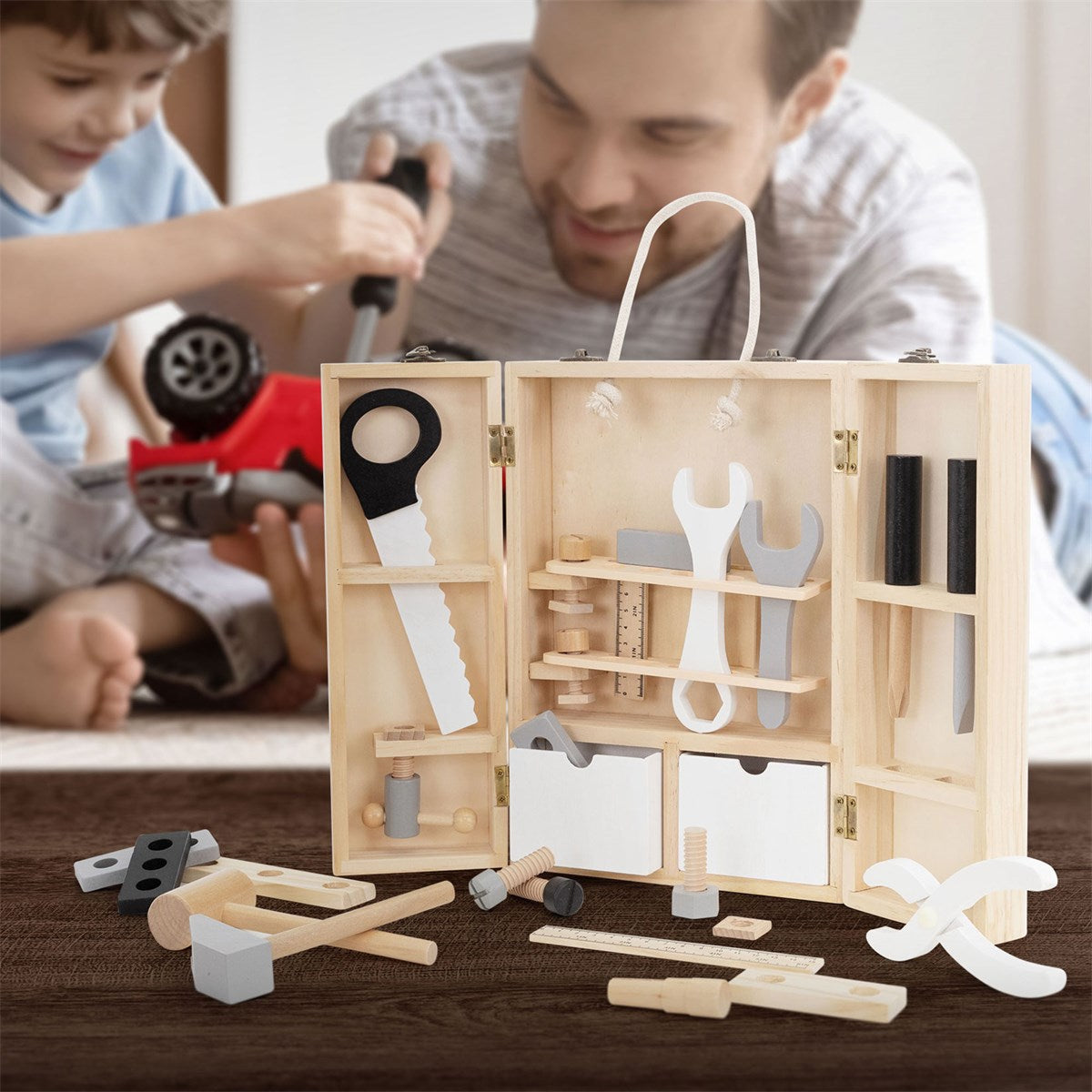 A child is playing with an open wooden box full of toy tools.