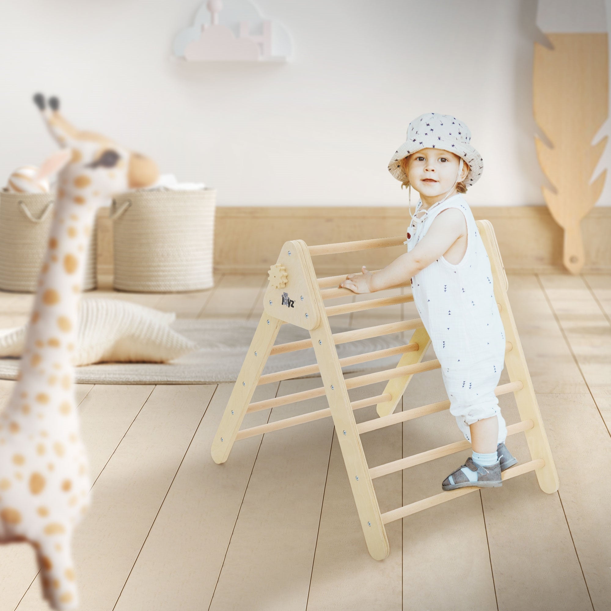 Ein Kind steht an einem Klettergerüst, während eine Giraffe im Vordergrund sichtbar ist.