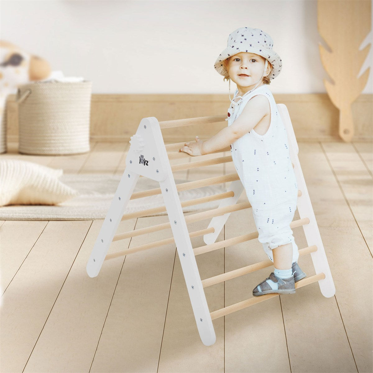A child stands at a climbing frame and holds onto the bars.