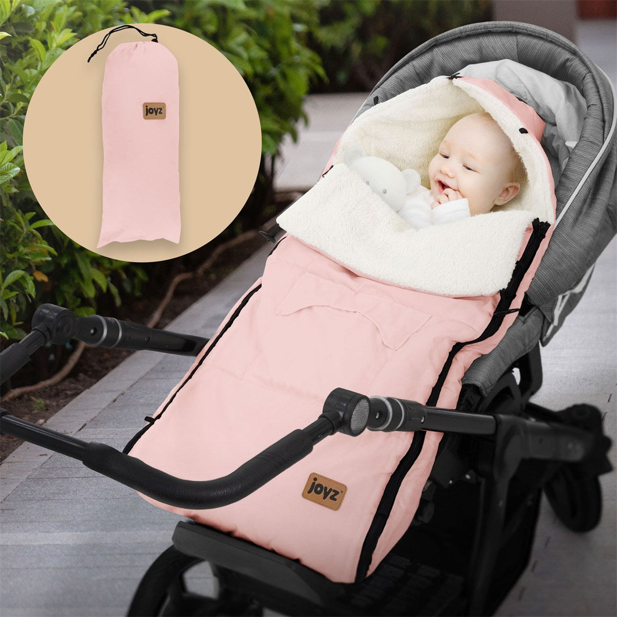 Pink baby footmuff, folded in a carrying bag.