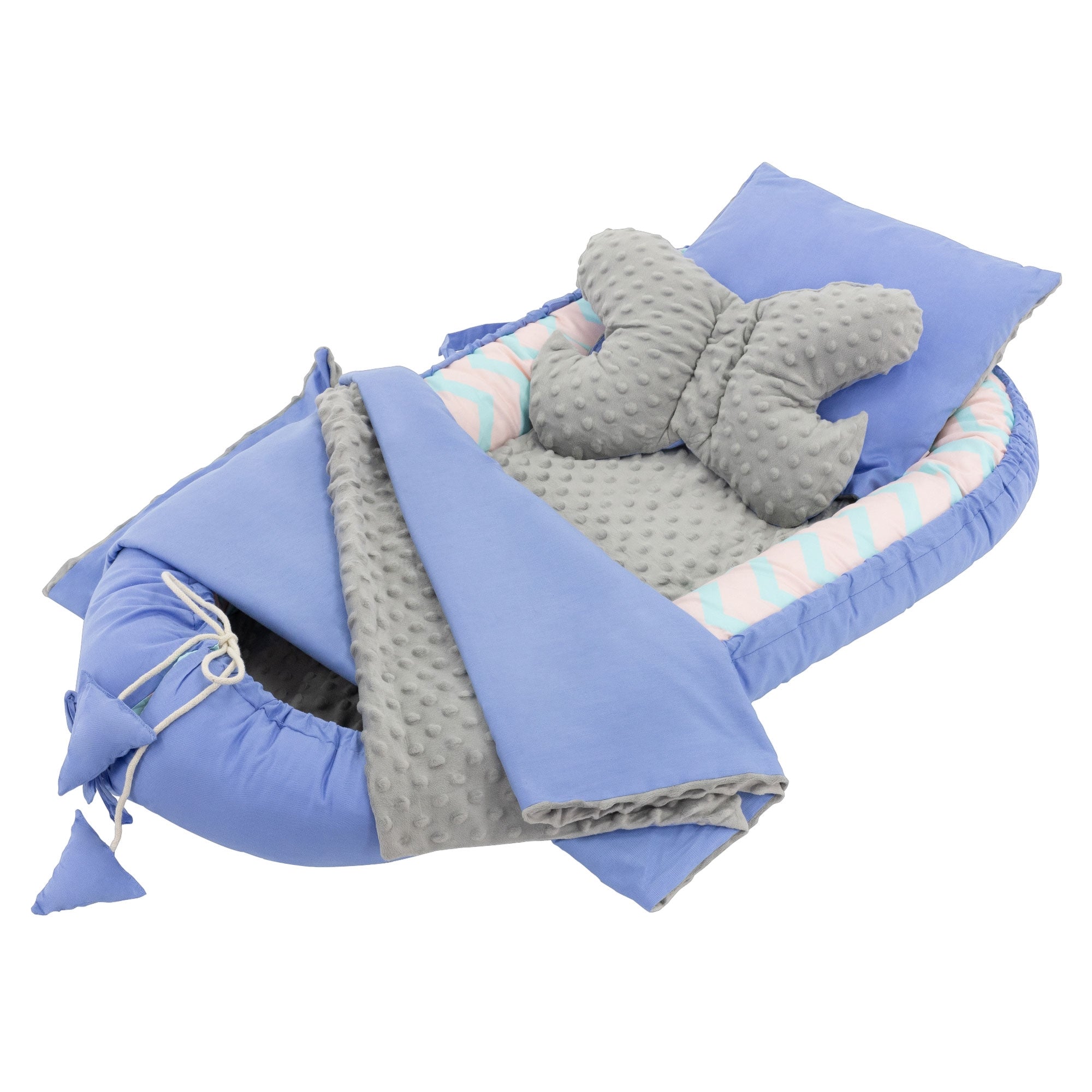 Ein blaues Babybett mit einem Schmetterlingskissen und einer gestreiften Decke.