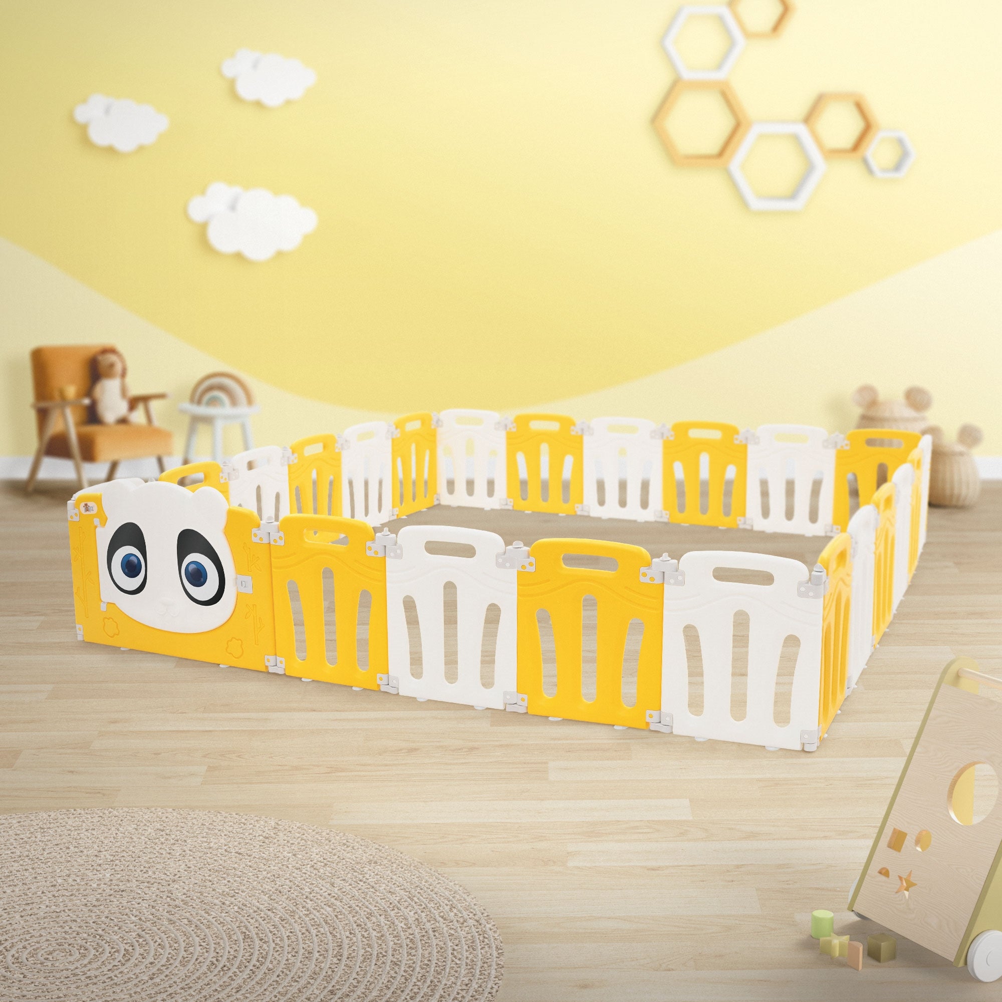 Gelber Spielzaun in einem hellen Raum mit Wolkenmotiven an der Wand.