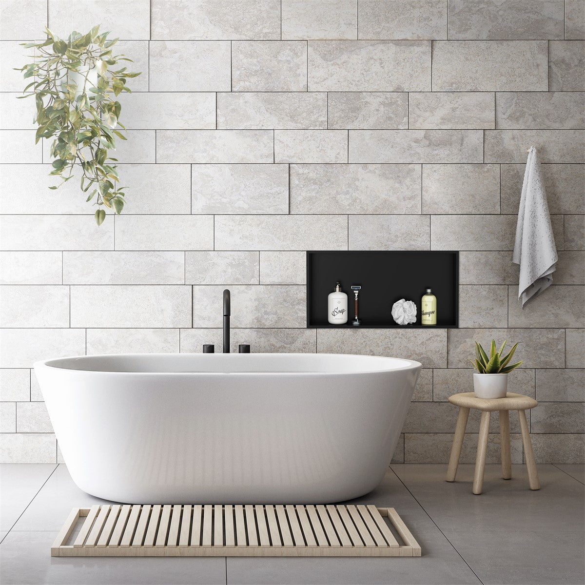 Baignoire îlot devant un mur en pierre avec des plantes et des produits de soin.