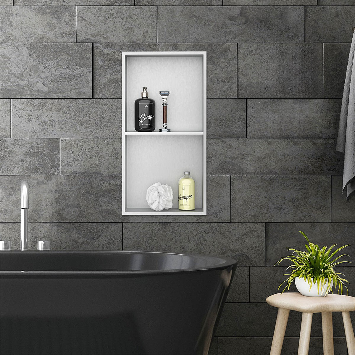 Wall niche with bathroom accessories above a black bathtub.