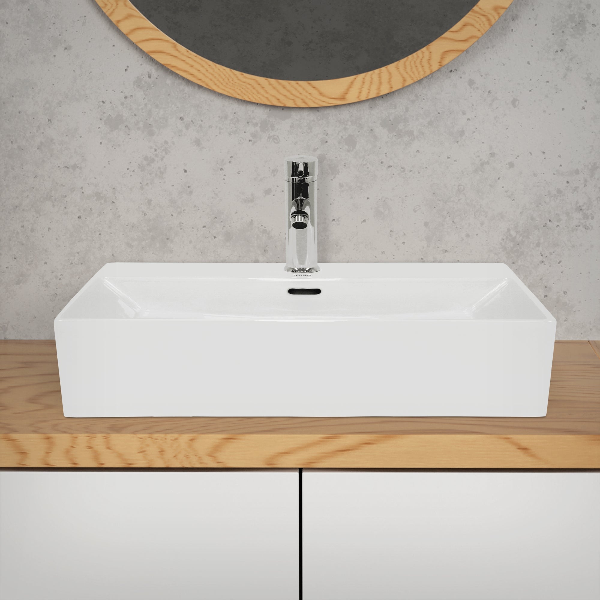 Witte wastafel op een houten plank voor een grijze muur met ronde spiegelomranding.
