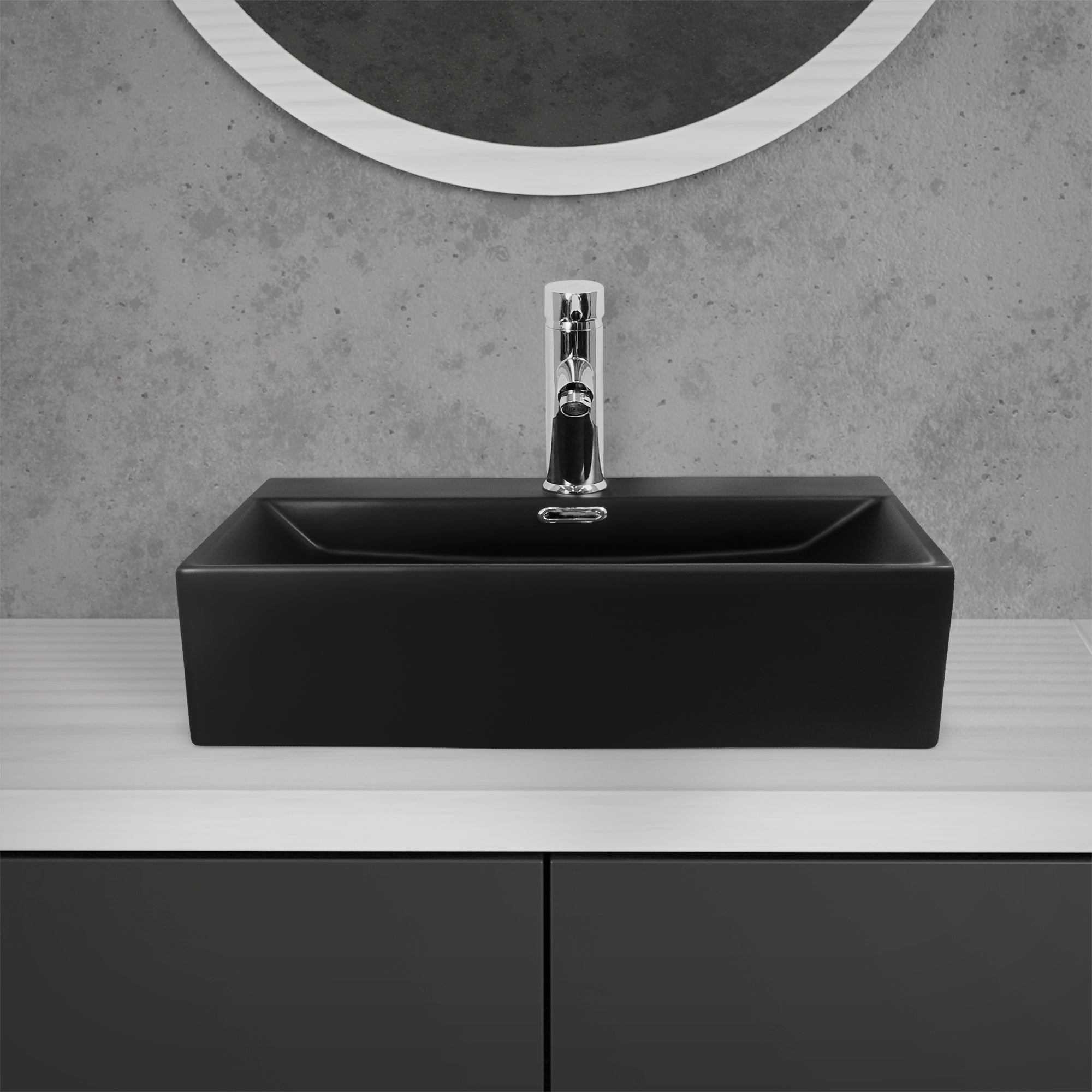 Lavabo negro sobre una mesa blanca con espejo al fondo.