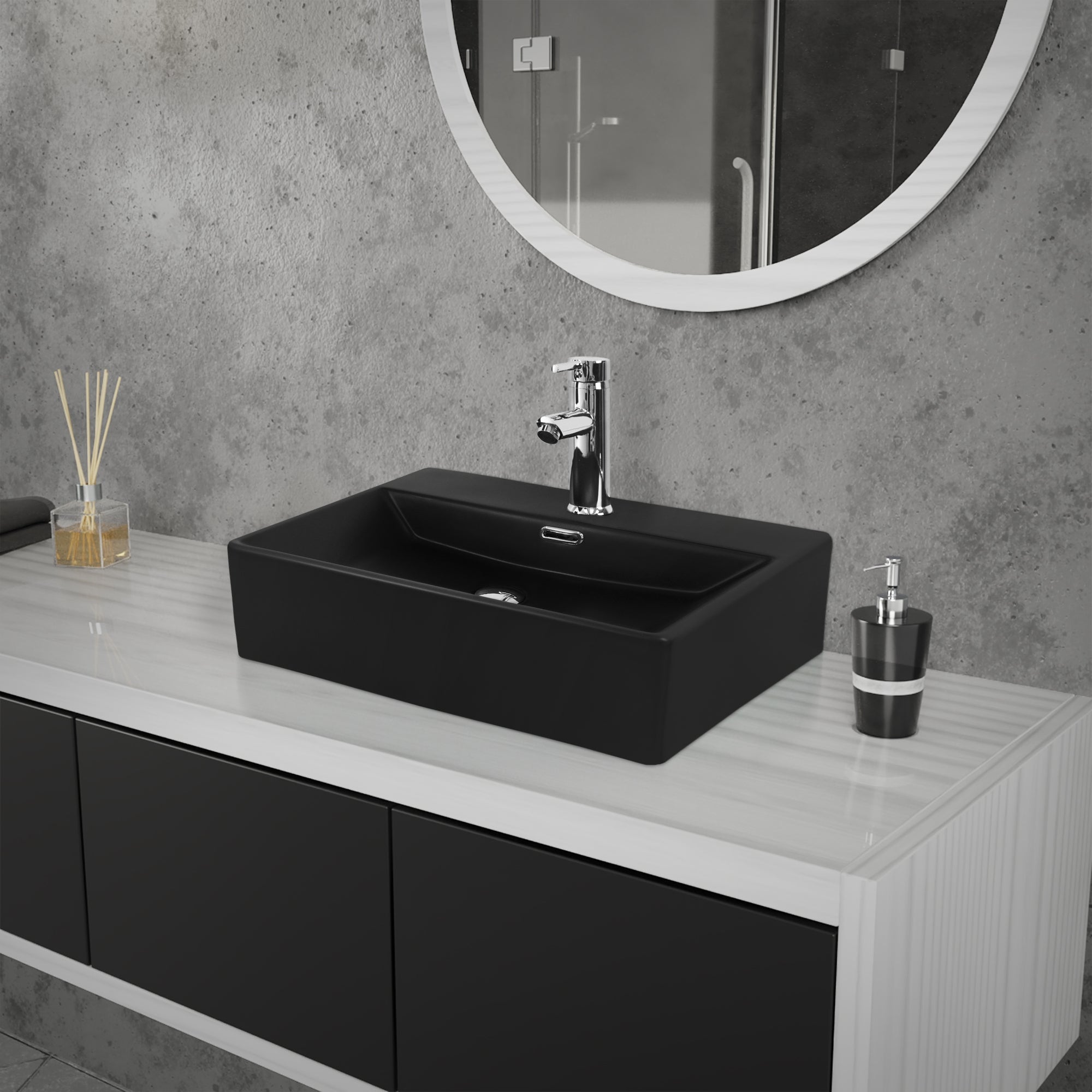 Lavabo negro sobre un mueble blanco frente a una pared gris.