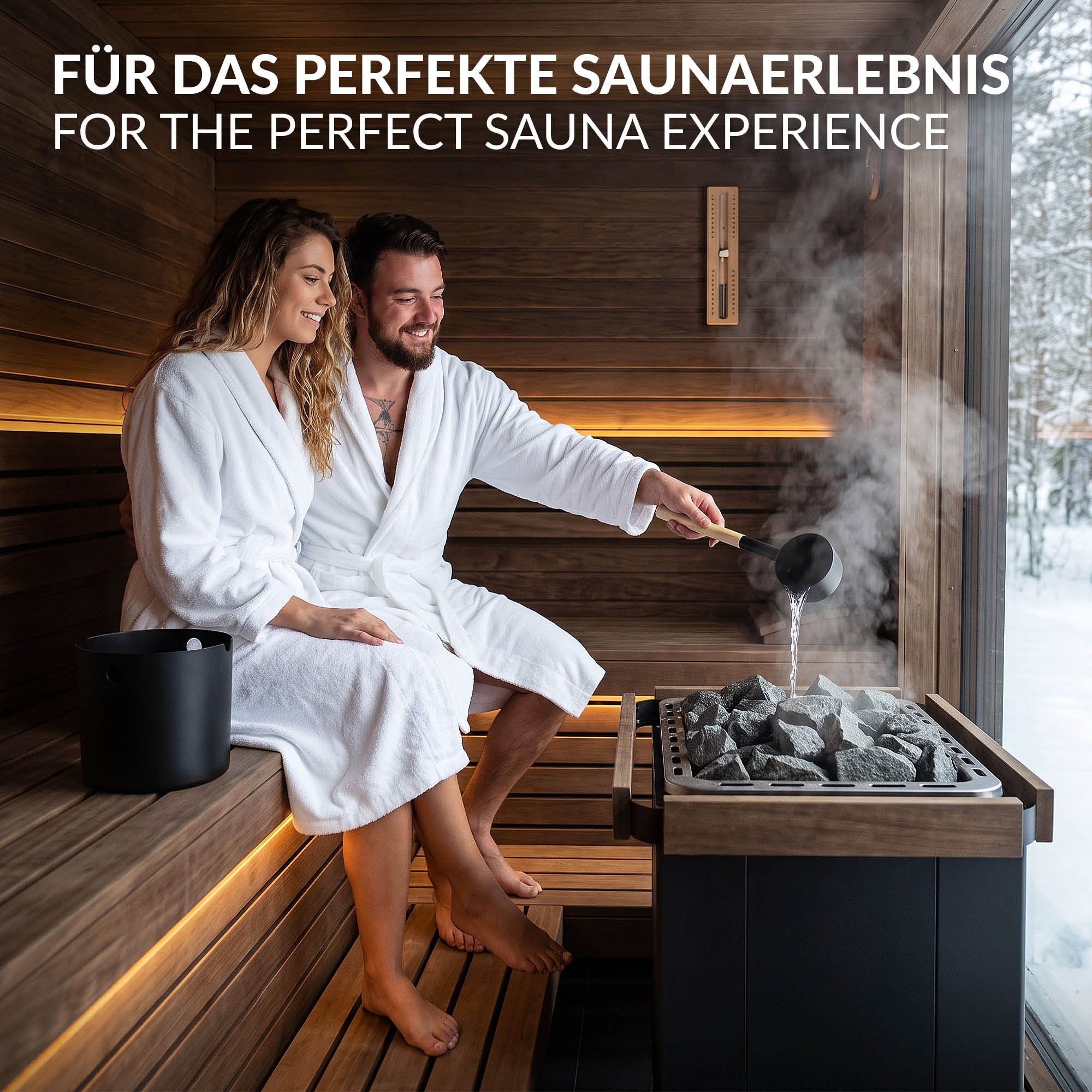 Paar in Saunakabine, beide in weißen Bademänteln, mit Saunasteinen und Wasserbehälter.