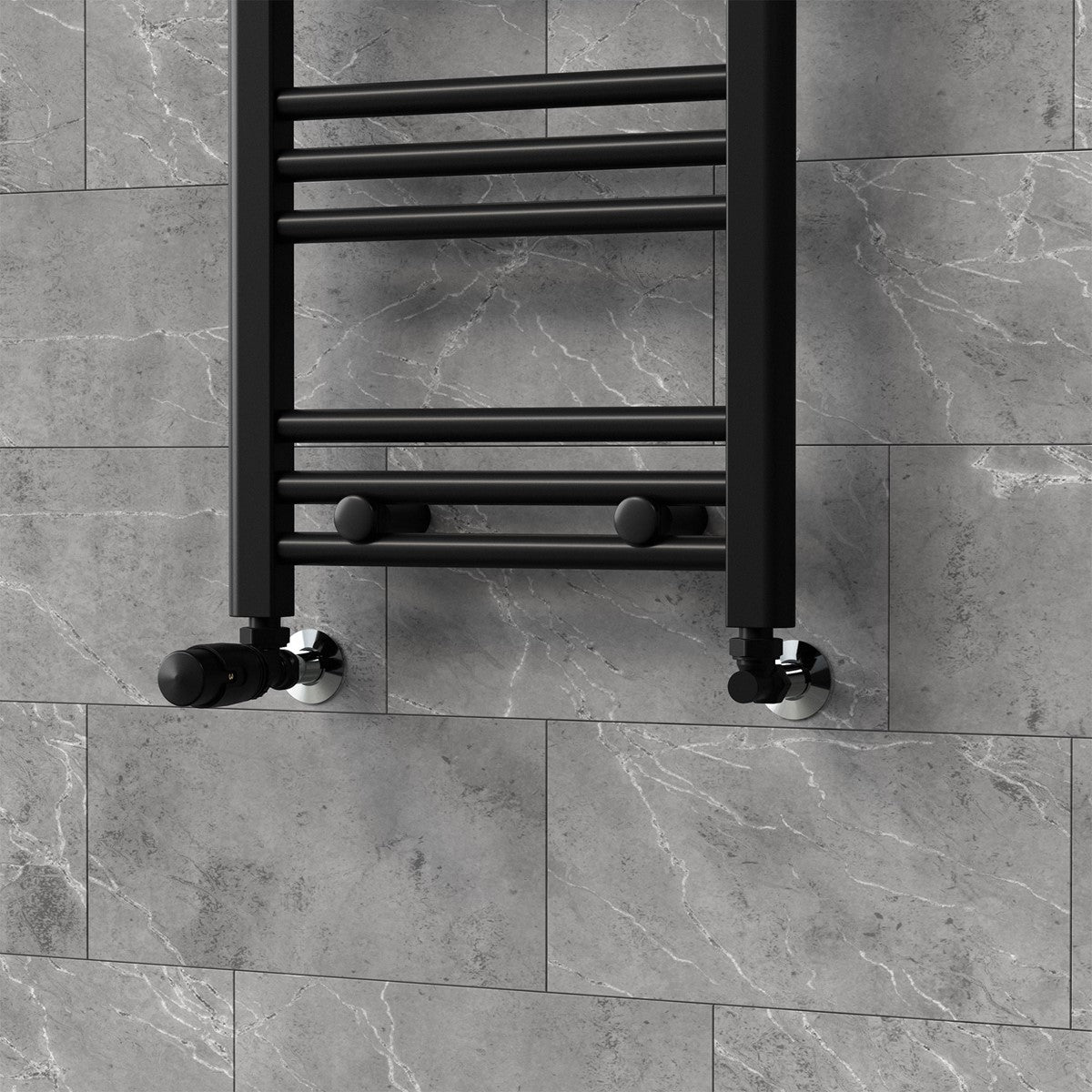 Radiateur à serviettes noir sur un mur gris.