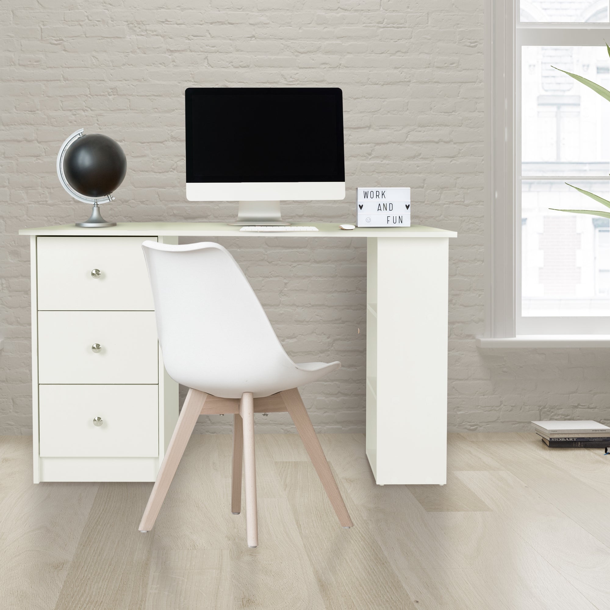 Escritorio con computadora, silla y globo en una habitación luminosa.