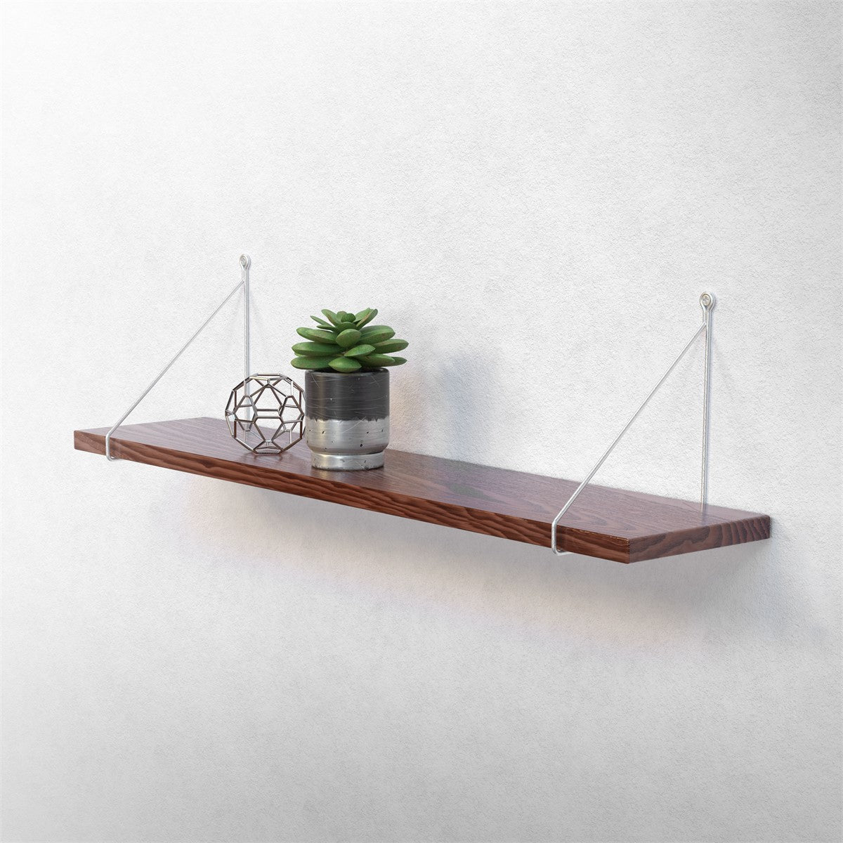 Étagère en bois avec des plantes et des décorations géométriques au mur.