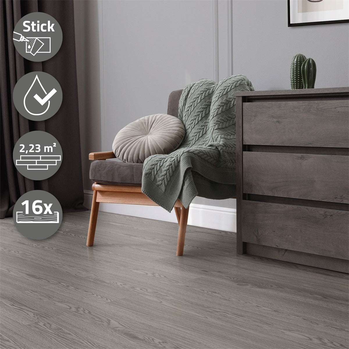 Living room with a gray floor, armchair, cushions, and a plant.