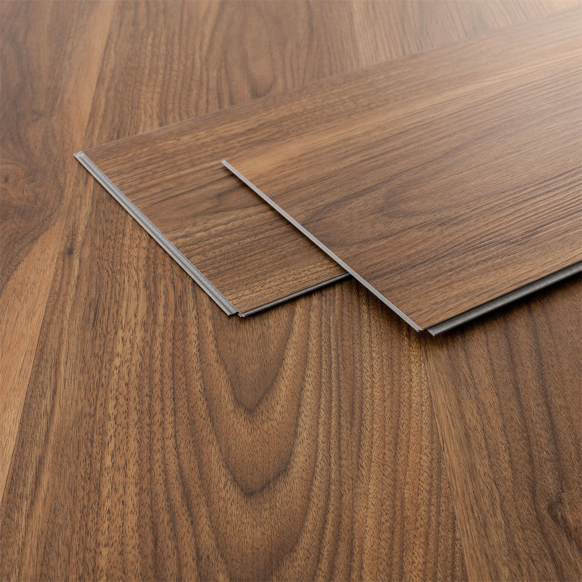 Two laminate boards in a dark wood look on a brown surface.