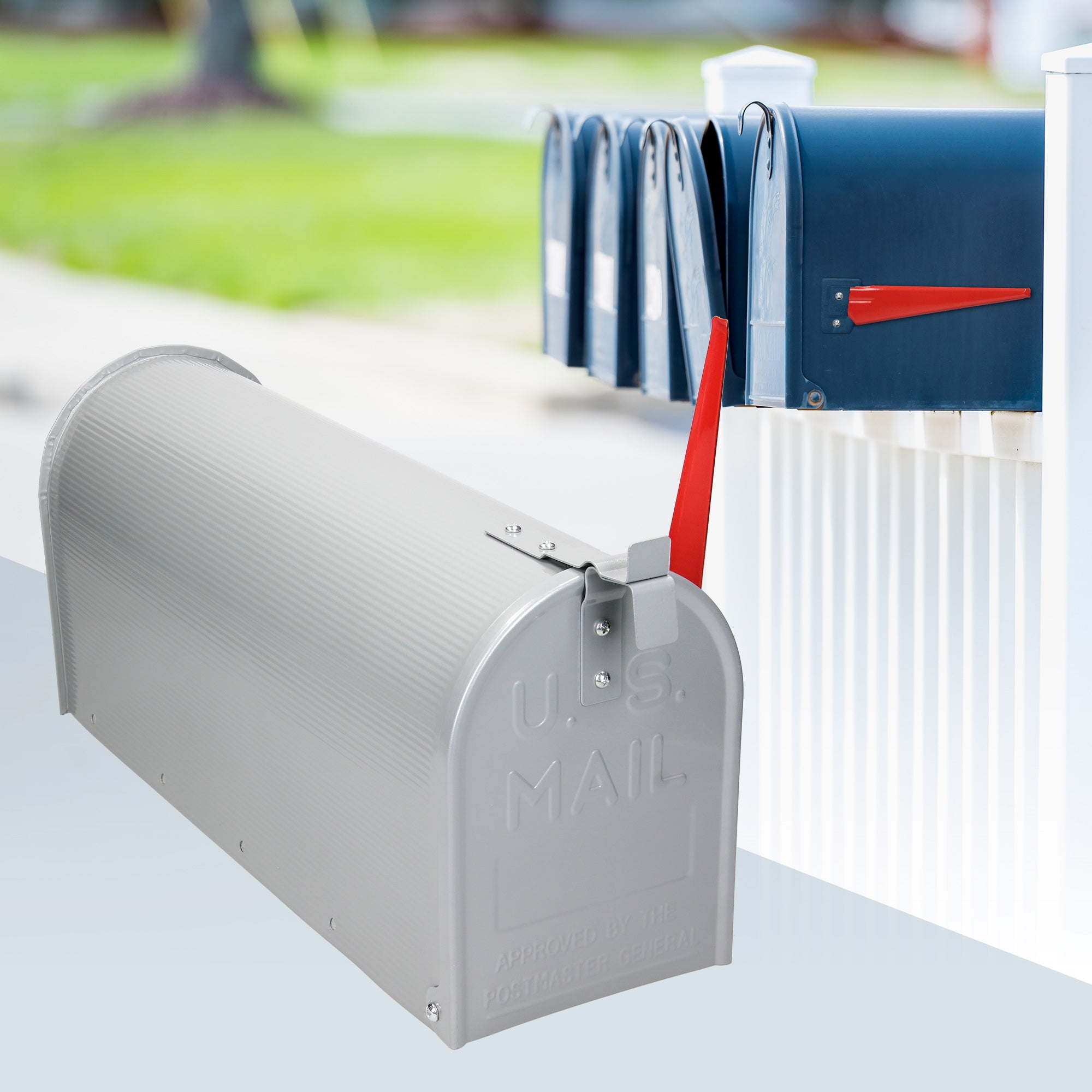 Boîte aux lettres grise avec un levier rouge à côté de plusieurs autres boîtes aux lettres.