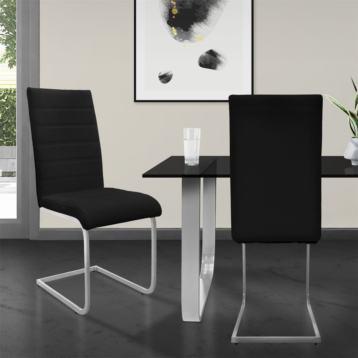 Zwei schwarze Stühle an einem Tisch mit Glasoberfläche in einem modernen Raum.