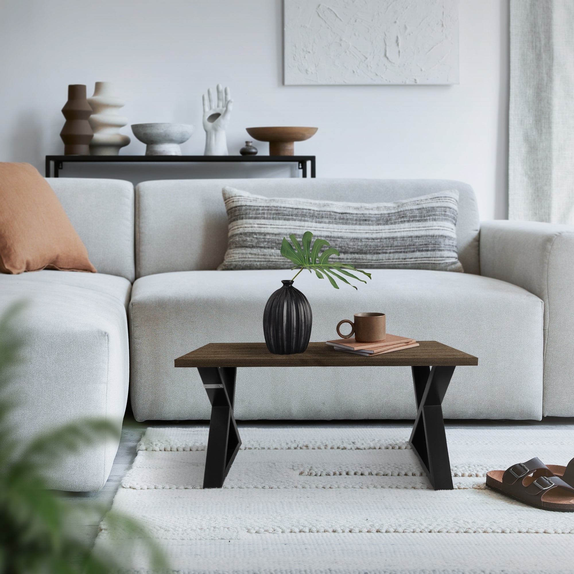 Gemütliches Wohnzimmer mit Sofa, Tisch und Pflanze auf dem Tisch.