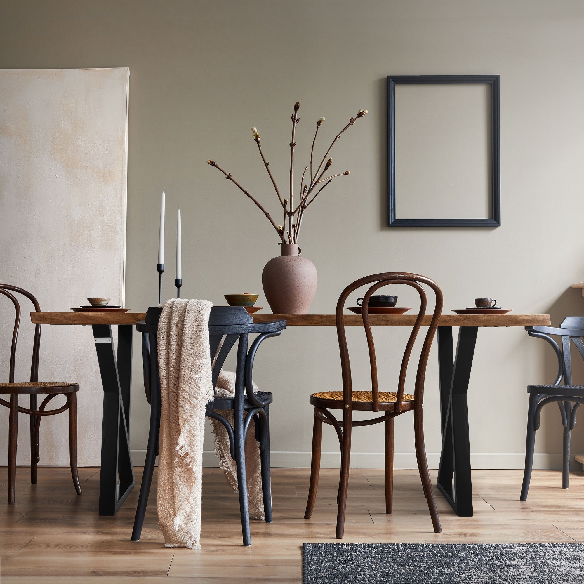Dining area with table, chairs, and a vase on a wooden floor.