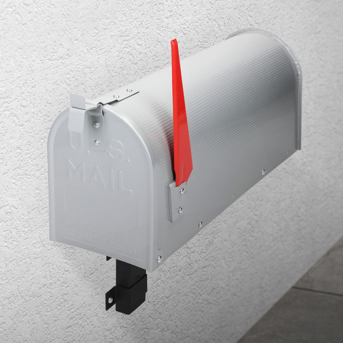 Silver mailbox on a wall with a red flag lever.