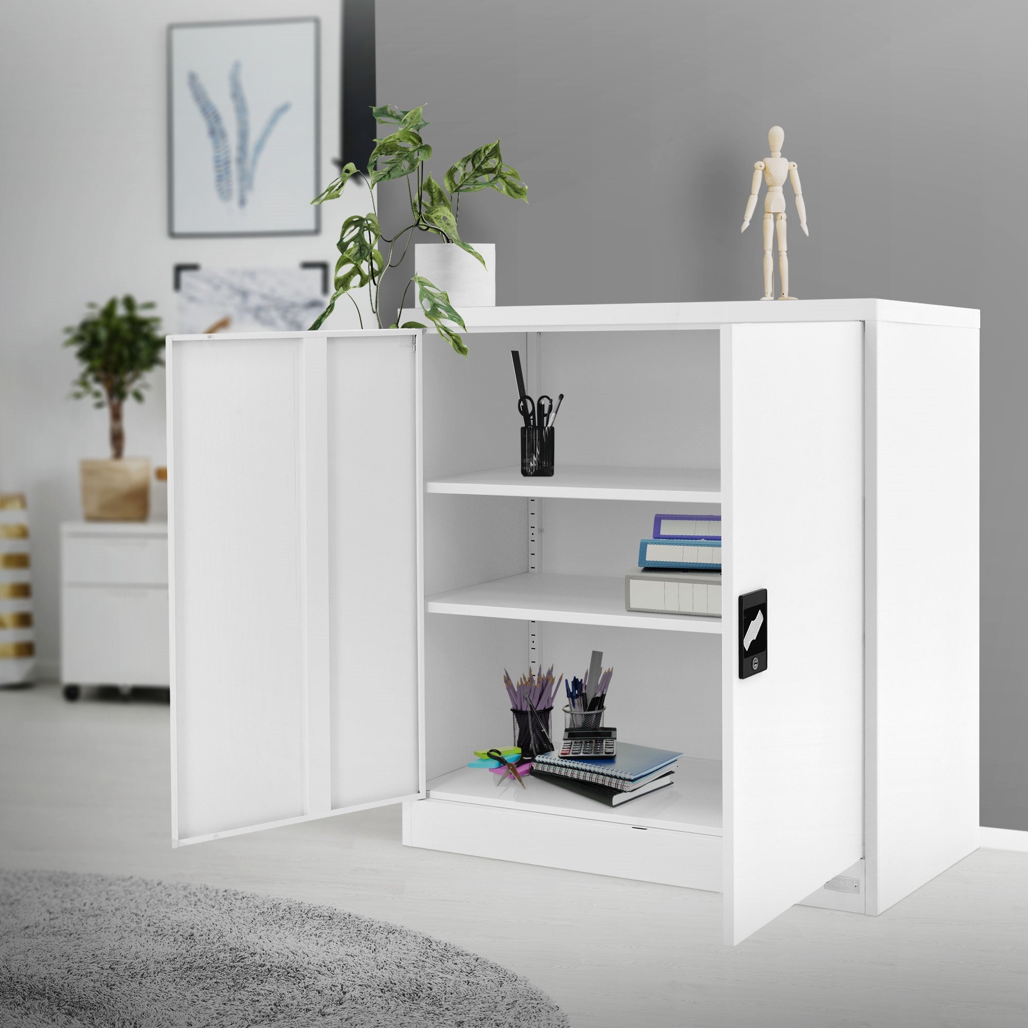 Weißer Schrank mit offenen Türen, Pflanzen und Figuren auf einem Tisch im Raum.