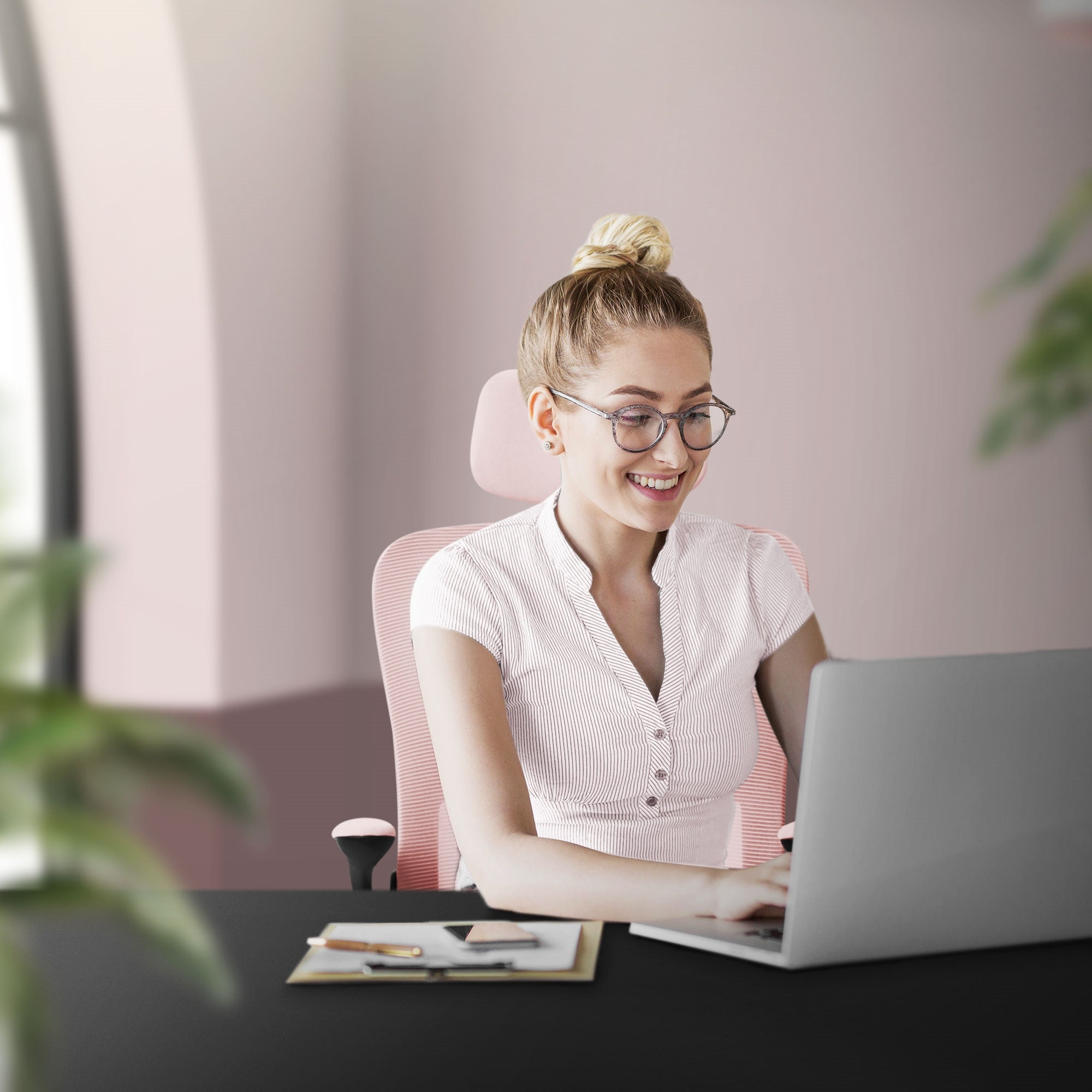 Woman sitting at a desk and working on a laptop.