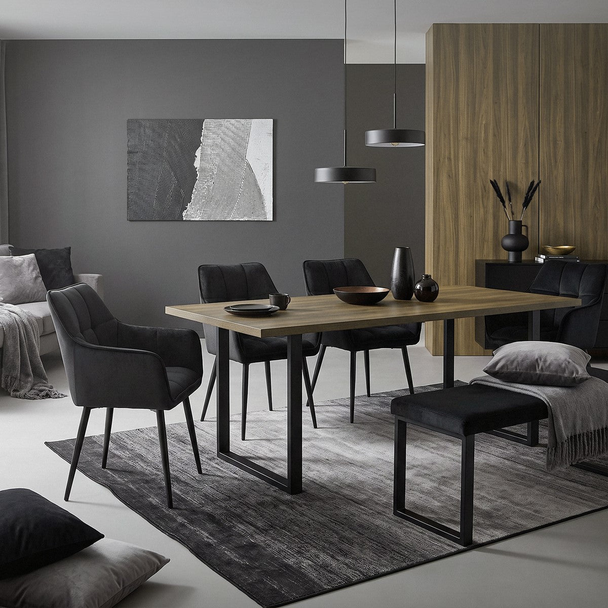 Spisestue med et bord og flere stole i et moderne rum.