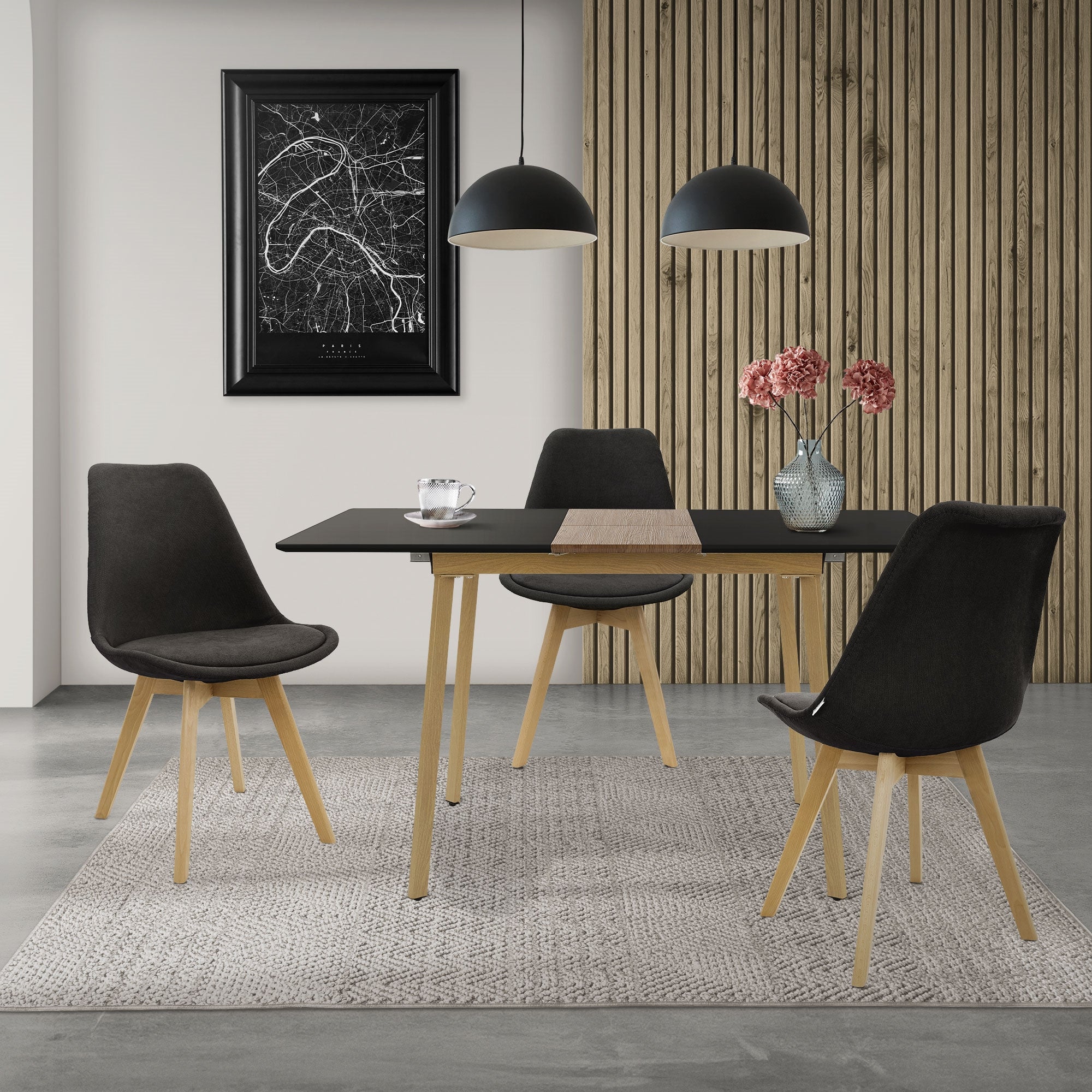 Ein Essbereich mit einem schwarzen Tisch, drei Stühlen und einer Wand mit Holzverkleidung.