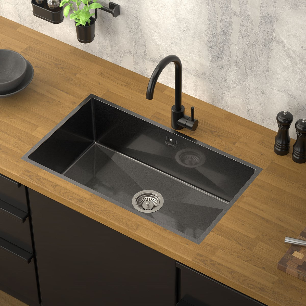 Black sink in a modern kitchen with a wooden countertop.