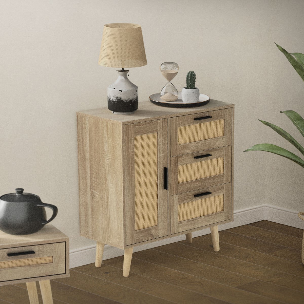Holzkommode mit zwei Türen und drei Schubladen, dekoriert mit Lampe und Pflanzen.