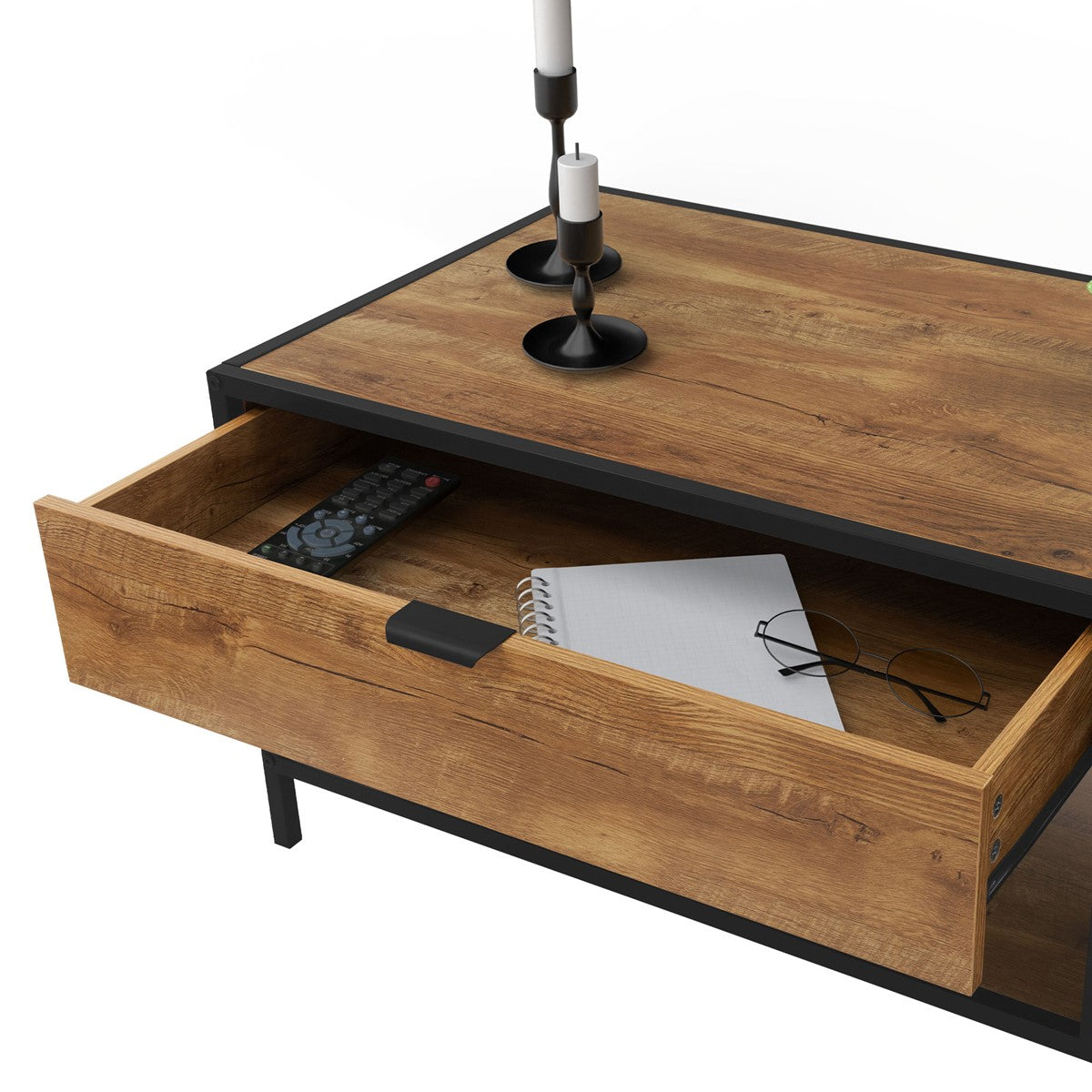 Tavolo in legno con un cassetto aperto, in cui si vedono un telecomando, un blocco per appunti e degli occhiali.