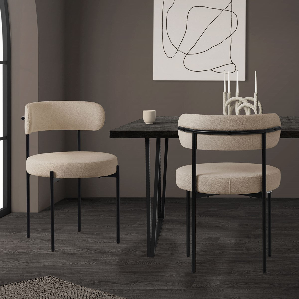 Two beige chairs stand at a table in a dark room.