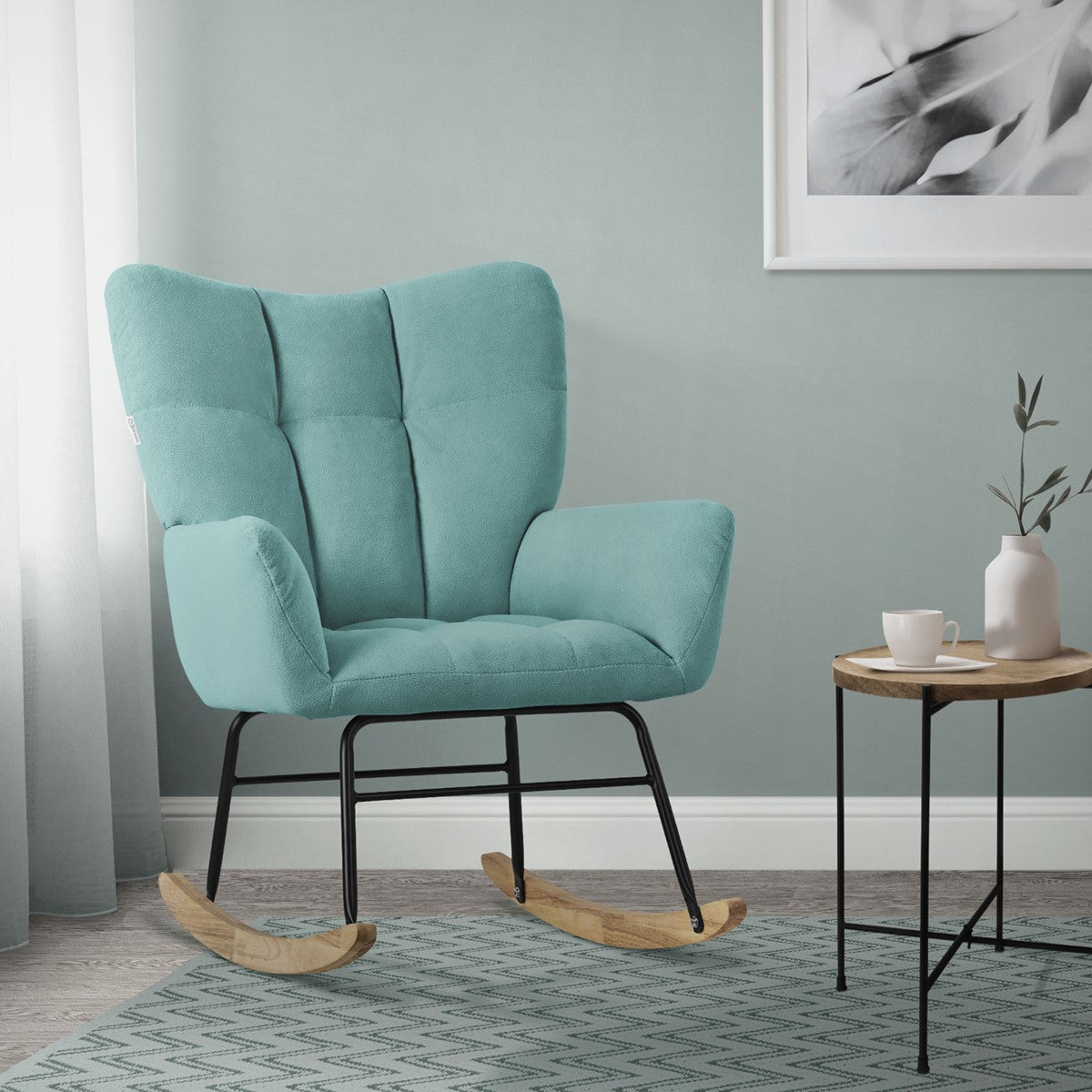 A turquoise rocking chair stands in a room with gray walls and a rug.