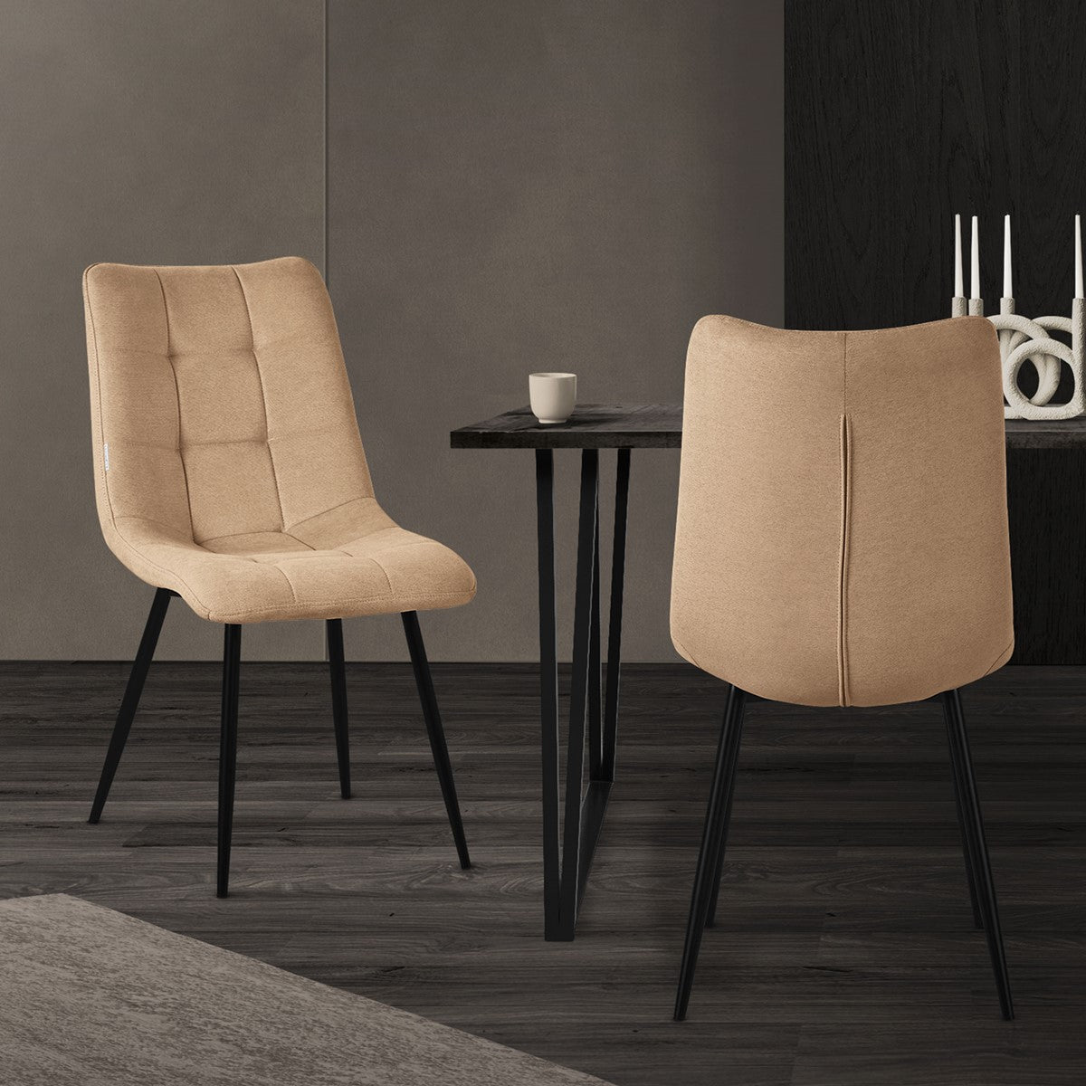 Zwei beige Stühle an einem Tisch in einem modernen Raum.