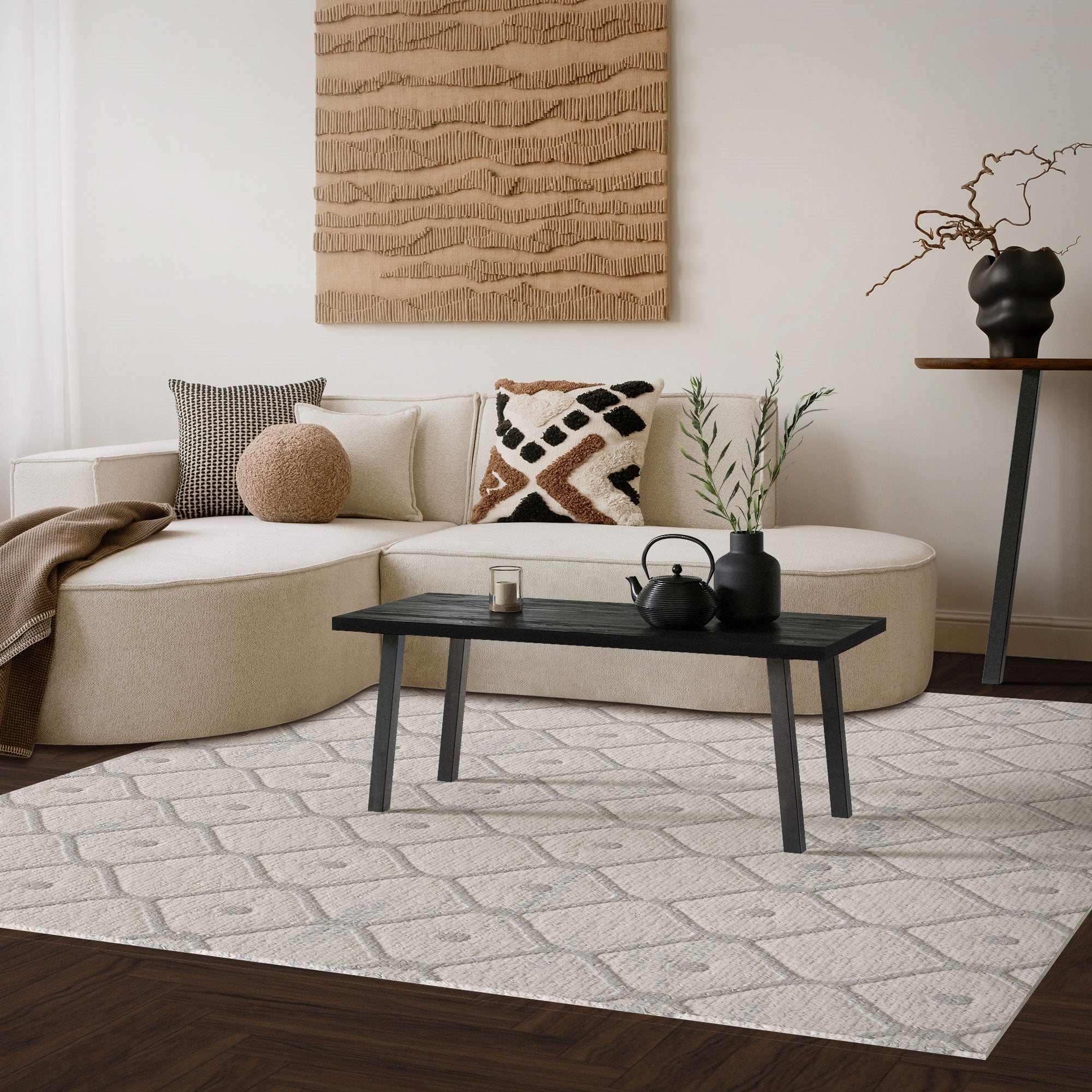 Espace de vie clair avec canapé, table et décoration sur un tapis.