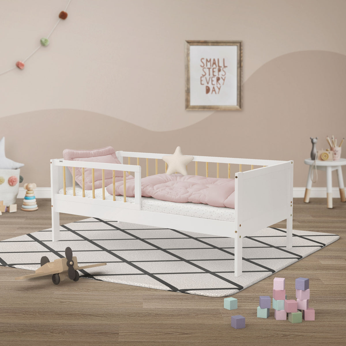 Bett im Kinderzimmer mit Kissen und Spielzeug auf einem Teppich.