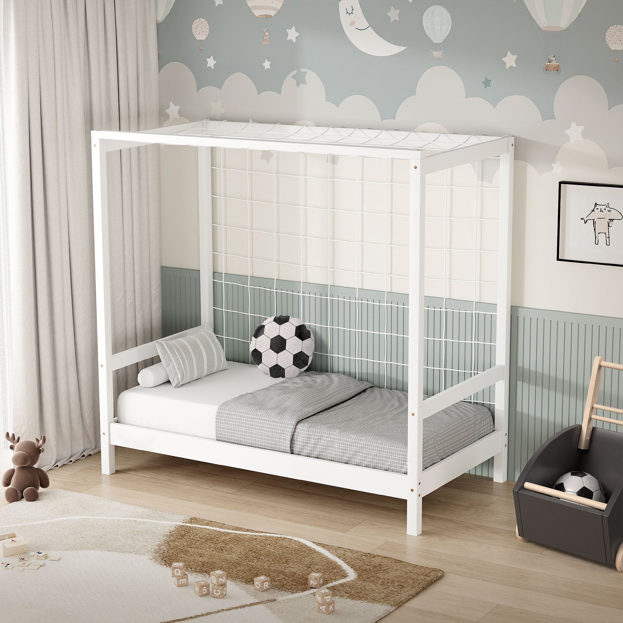 Ein weißes Kinderbett mit einem Fußball und Kissen auf einer Matratze.