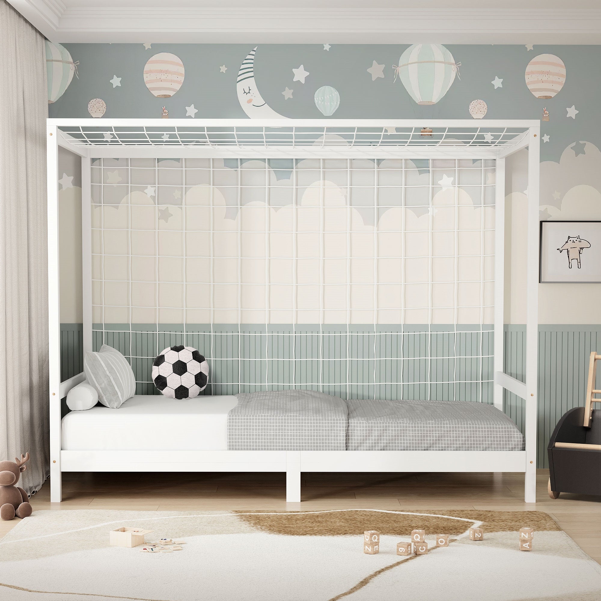 Cama infantil blanca con barandilla, balón de fútbol y decoración en la pared.