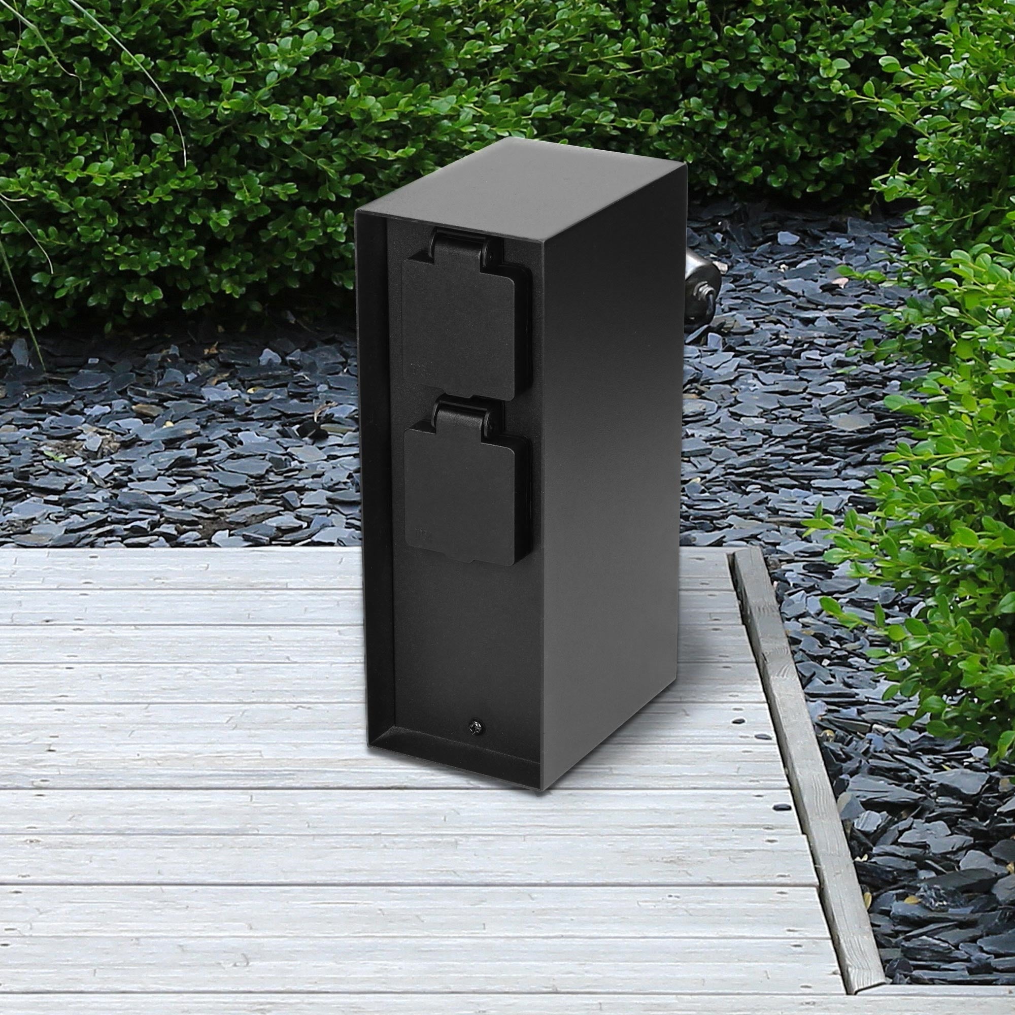 Caja negra sobre plataforma de madera con piedras de fondo.