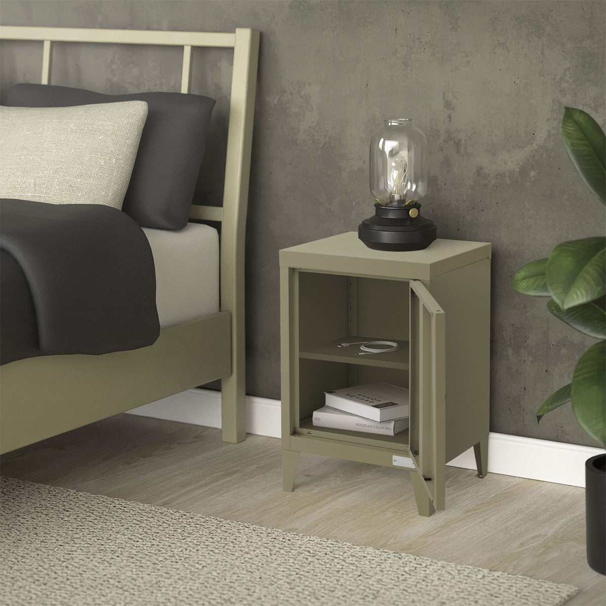 Beige bedside table with the door open, a lamp and plants in the background.