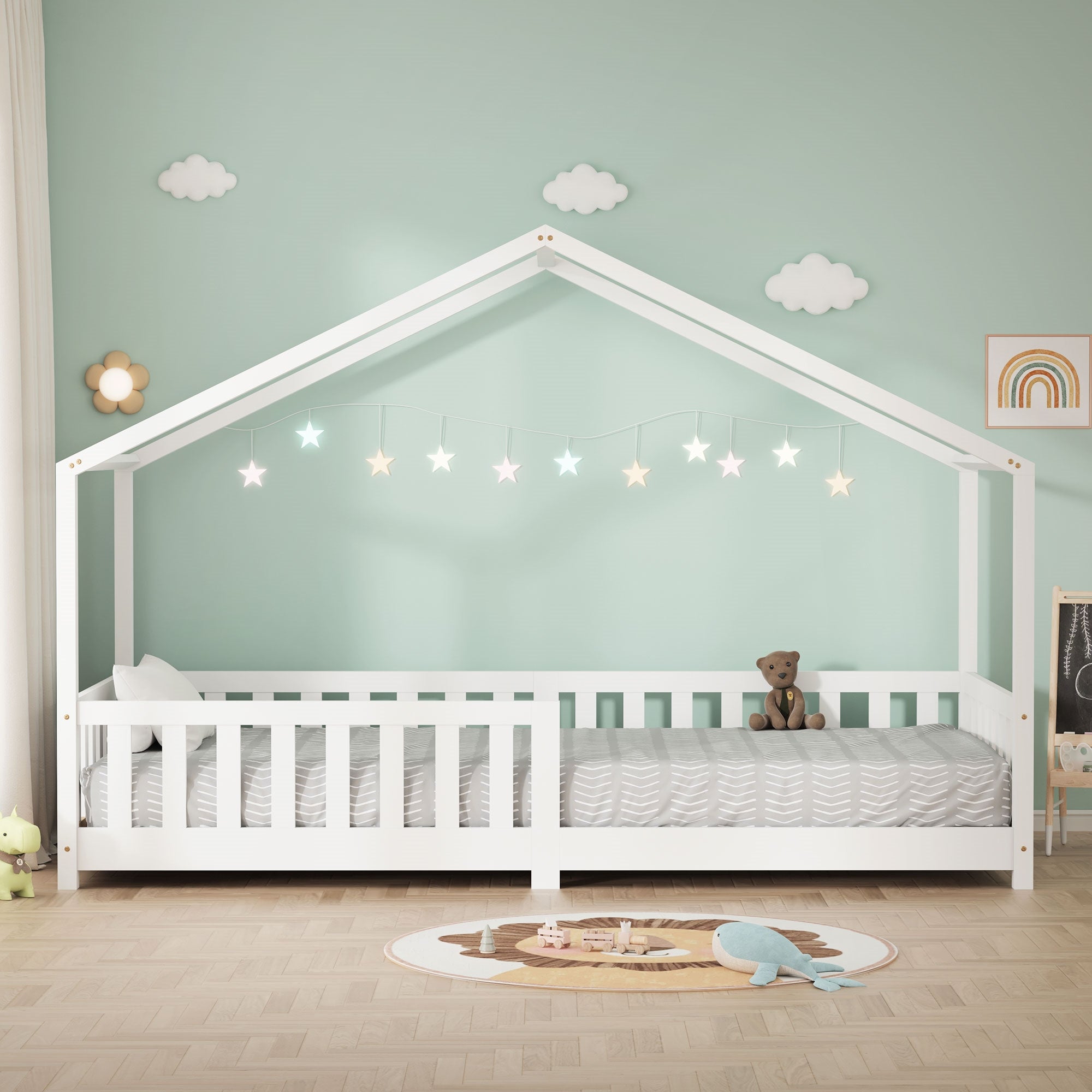 Ein Kinderbett in Hausform mit Sternenlichtern und einem Teddy auf der Matratze.