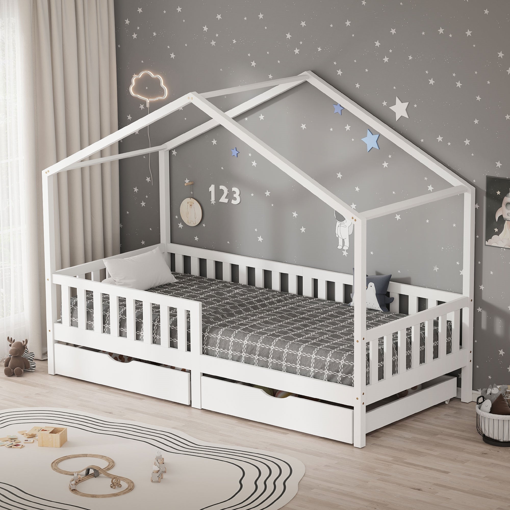 Weißes Kinderbett im Hausdesign mit grauer Wand und Spielzeug auf dem Boden.