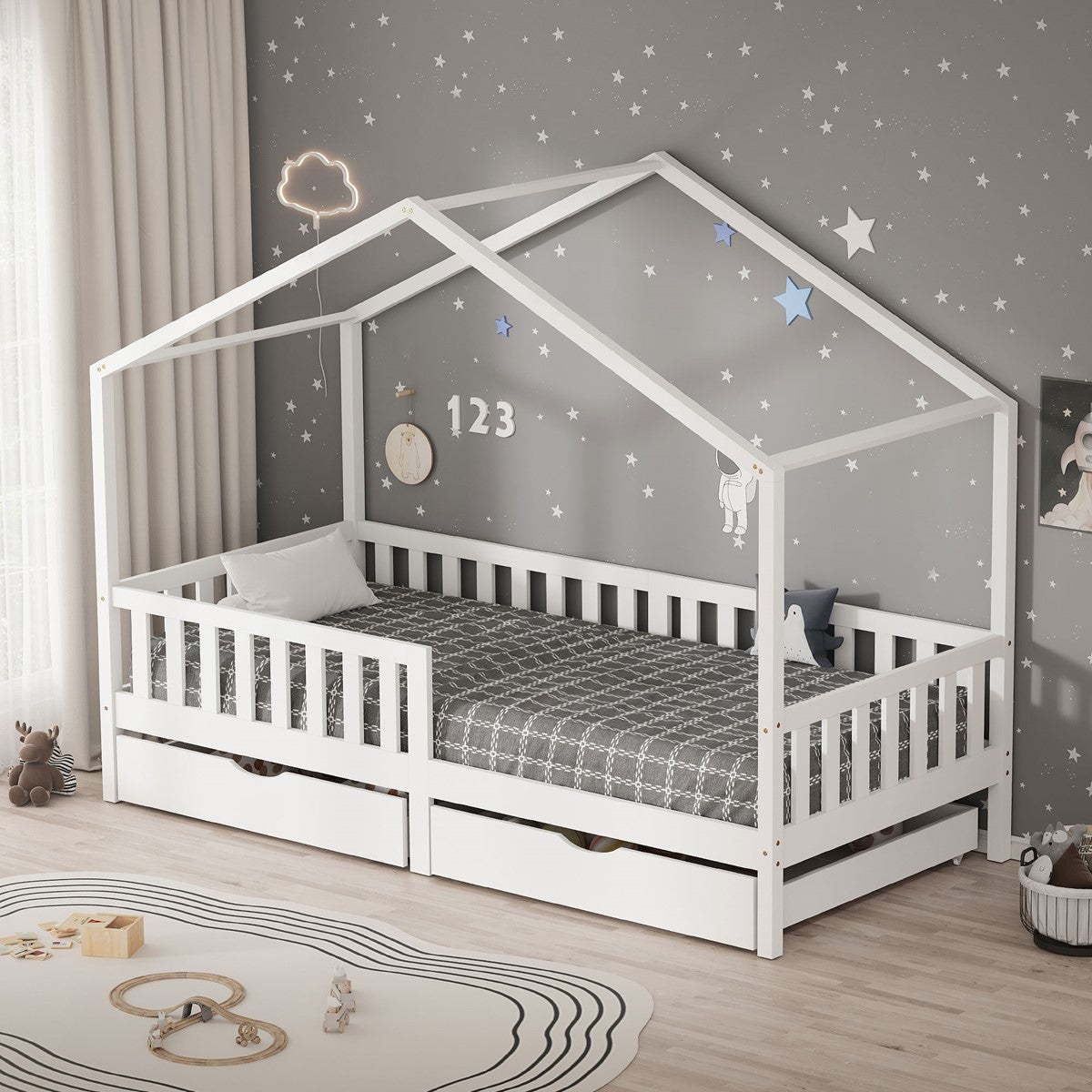 Cama-casinha branca com grades laterais e duas gavetas num quarto infantil com papel de parede cinzento com estrelas.