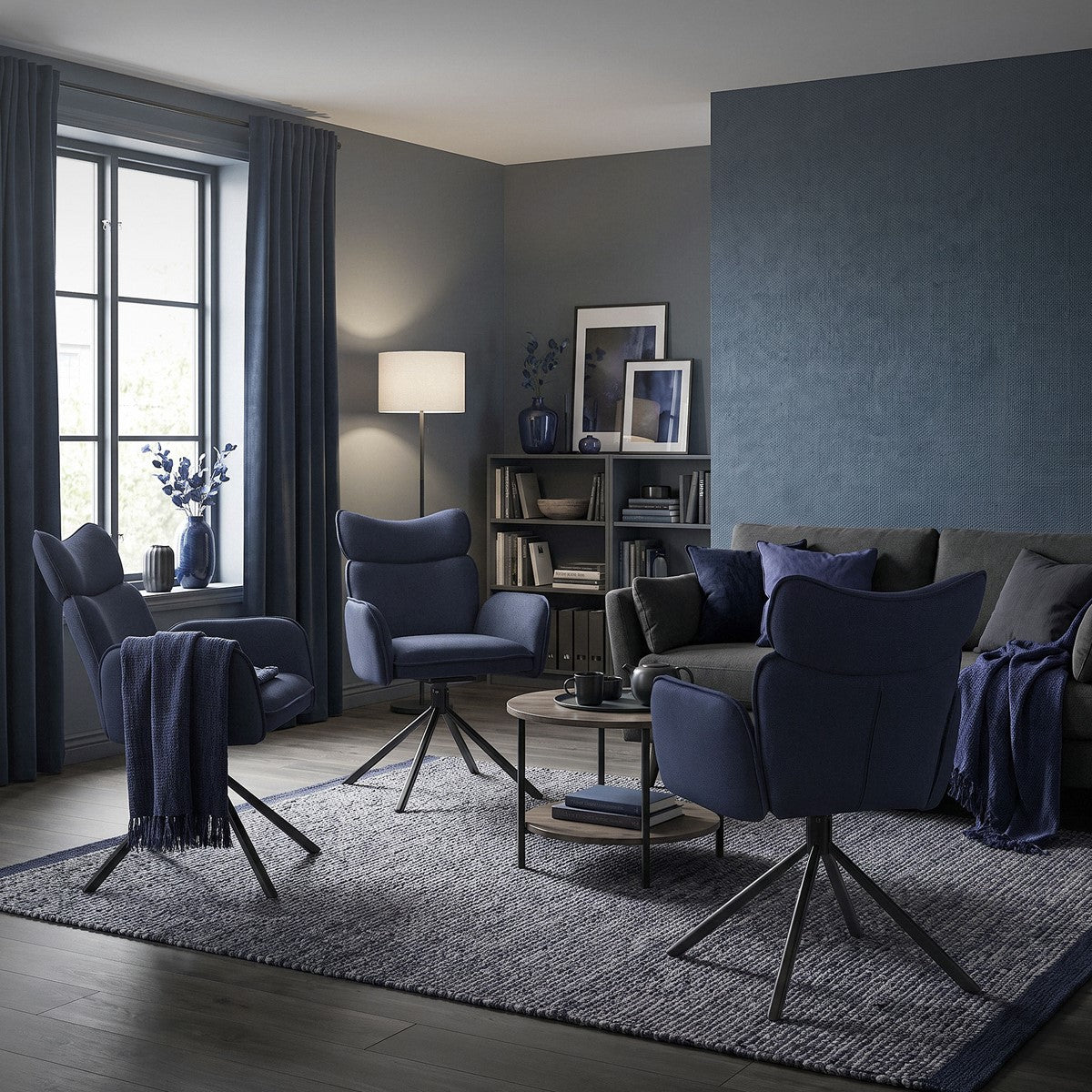Uma cadeira azul numa sala de estar elegante com uma estante de livros.